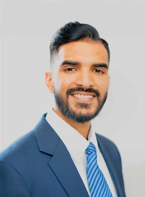 Dr. Cardin Chellan in a suit and tie against a light background